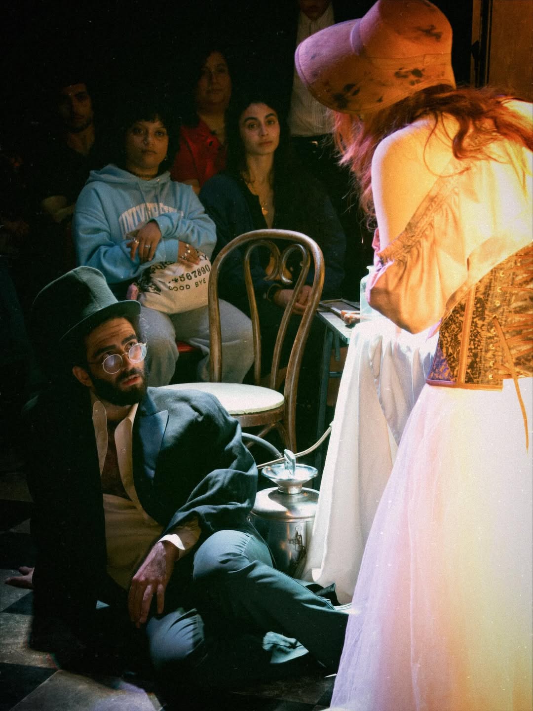 Dr. Darwin, brought to his knees by a fit of coughing, looks up at Ms. Comfort, who leans over him sympathetically.